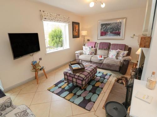 a living room with a couch and a tv at Coast Cottage in Bamburgh