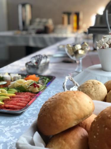 a table topped with plates of food and a plate of vegetables at Resto Inn - Smart apartamenty blisko Energylandii in Po”łwieś