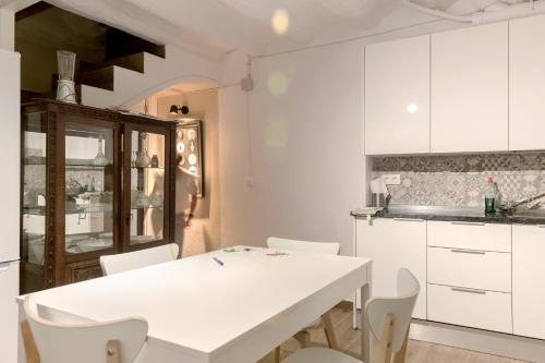 une cuisine avec une table blanche et des armoires blanches dans l'établissement Añisclo, à Barbastro