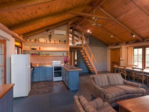 una cocina abierta y una sala de estar en una casa pequeña en Cloudy Creek Cottage, en South Bruny