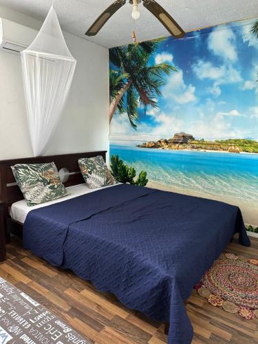 een slaapkamer met een blauw bed en uitzicht op de oceaan bij Villa des Stars xtelx0690x07xx1415xx in Saint-François