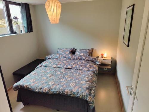 a small bedroom with a bed and a night stand at Modern and comfortable apartment in attractive neighborhood in Stavanger