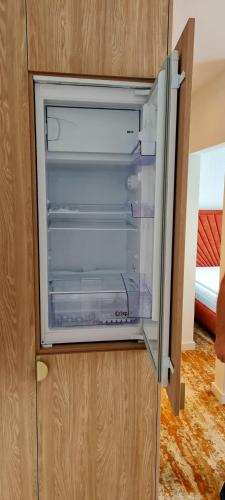 an empty refrigerator with its door open in a cabinet at Bel Mare Aqua Resort B&M in Międzyzdroje