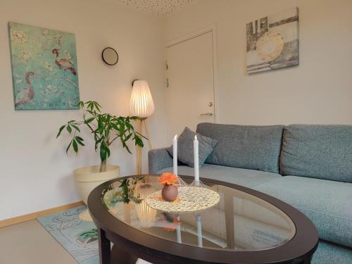 uma sala de estar com um sofá e uma mesa de vidro em Modern and comfortable apartment in attractive neighborhood em Stavanger