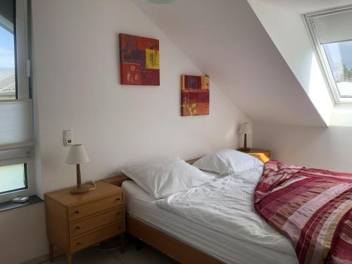 - une chambre avec un lit et deux photos sur le mur dans l'établissement am Heider Bergsee, à Brühl