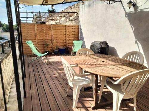 une table et des chaises en bois sur une terrasse en bois dans l'établissement Appartement Pontet climatisé pour 4 personnes, à Avignon