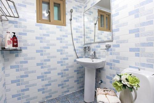 a blue and white bathroom with a sink and a toilet at Suncheon Bay Healing Pension in Suncheon