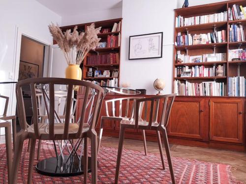 comedor con mesa, sillas y estanterías en Belle maison de maître à 200 m du Canal du midi, en Castelsarrasin
