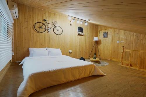 a bedroom with a bed and a bike hanging on the wall at Suncheon Bay Healing Pension in Suncheon
