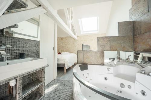 y baño con bañera y lavamanos. en My Home Prestige / SPA Privatif en Châteauroux