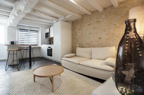 un salon avec un canapé blanc et une table dans l'établissement My Home Prestige / SPA Privatif, à Châteauroux