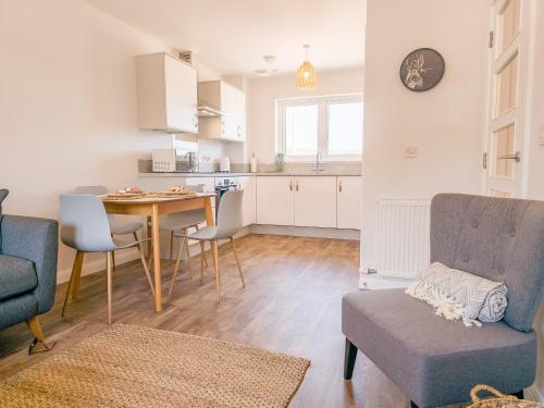 a kitchen and living room with a table and chairs at 4 Ben Avon in Aviemore