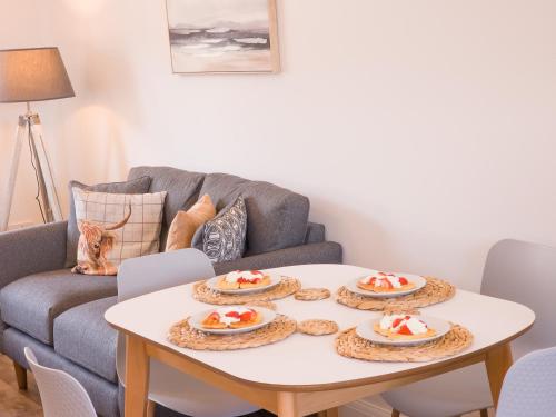 a living room with a table with plates of food on it at 4 Ben Avon in Aviemore