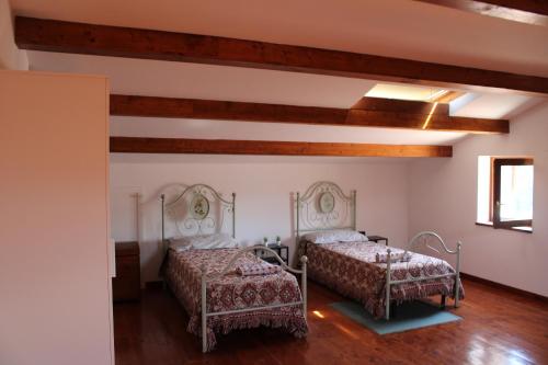 two beds in a room with wooden ceilings at Relax and apartment in SantʼAgata Feltria