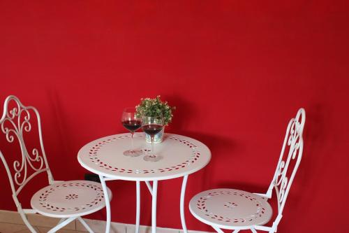 a table with two chairs and two glasses of wine at Relax and apartment in SantʼAgata Feltria