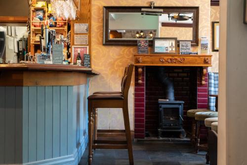 um bar com um balcão de madeira e uma lareira em The White Horse Inn em Holmfirth