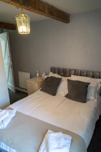 a bedroom with a large white bed with two pillows at The White Horse Inn in Holmfirth