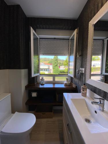 La salle de bains est pourvue de toilettes, d'un lavabo et d'une fenêtre. dans l'établissement La Goleta, à Avilés