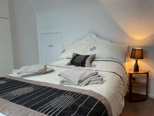ein großes Bett mit weißer Bettwäsche und Kissen darauf in der Unterkunft Forestbrook in Rostrevor