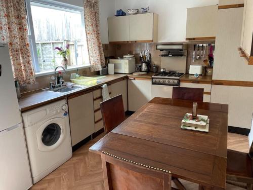 eine Küche mit einem Tisch und einer Waschmaschine in der Unterkunft Forestbrook in Rostrevor
