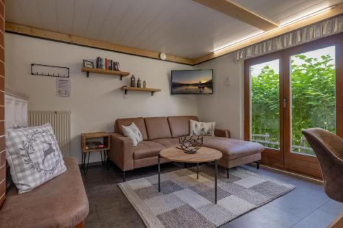 a living room with a couch and a table at Almhütten Sonnblick & Almfried in Sonnenalpe Nassfeld