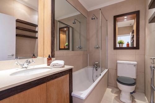 La salle de bains est pourvue d'un lavabo, d'une baignoire et de toilettes. dans l'établissement Stay at Kensington and Knightsbridge, à Londres