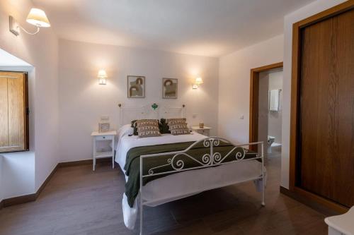 a bedroom with a bed and a table in a room at Casa do Forno (Vale Luis Neto-Retiro do Caldeirão) in Loulé