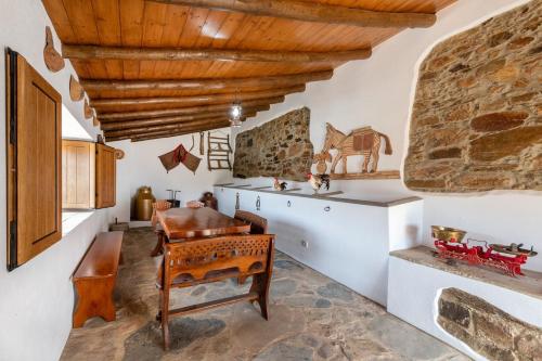 a kitchen with a wooden ceiling and a table at Casa do Forno (Vale Luis Neto-Retiro do Caldeirão) in Loulé