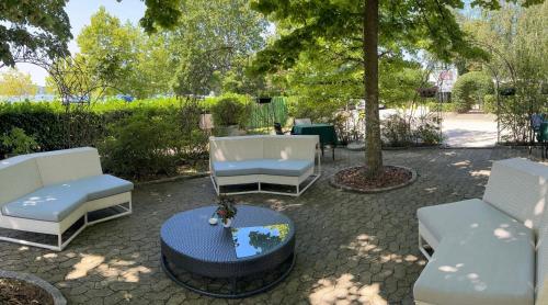eine Gruppe Stühle und ein Tisch auf einer Terrasse in der Unterkunft Hotel Ristorante Mariuccia Varese in Varese