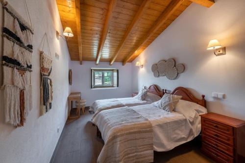 a bedroom with two beds and a wooden ceiling at Casa do Forno (Vale Luis Neto-Retiro do Caldeirão) in Loulé