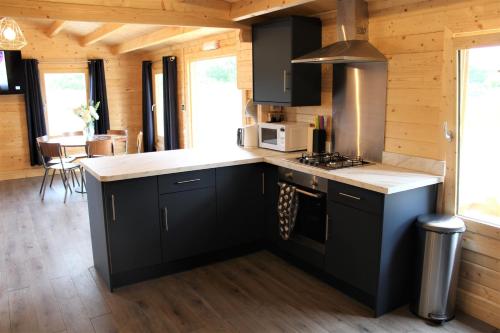 a kitchen with black cabinets and a counter top at Inviting 3-Bedroom Lodge in Ashton Under Hill in Evesham