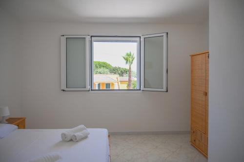a white room with a bed and a window at Villa Carlotta con piscina in Noto Marina