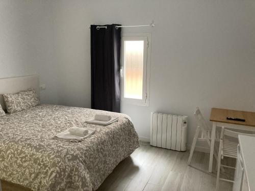1 dormitorio con 1 cama con 2 toallas en Casa de Huéspedes Cinco Torres, en Madrid