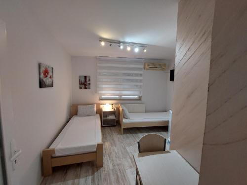 um pequeno quarto com uma cama e um sofá em Apartments Sofija em Niš