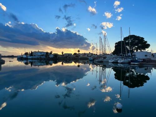 a group of boats docked in a marina at sunset at BLAU Apartamento frente a los canales y las puestas de sol de Roses in Roses