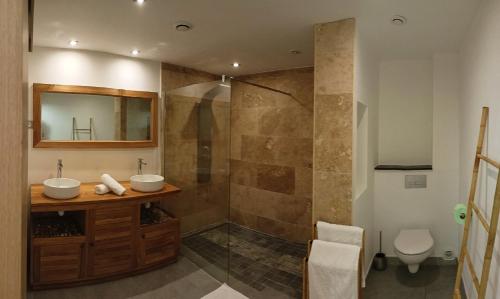 a bathroom with two sinks and a shower at Maison F3 mitoyenne avec piscine partagée et jardin privatif - Résidence Plaiz'Anse in Petite Île