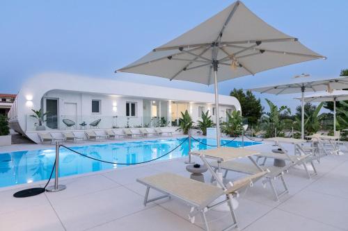 a pool with chairs and umbrellas next to a building at Stellaris Apartrooms in Termoli