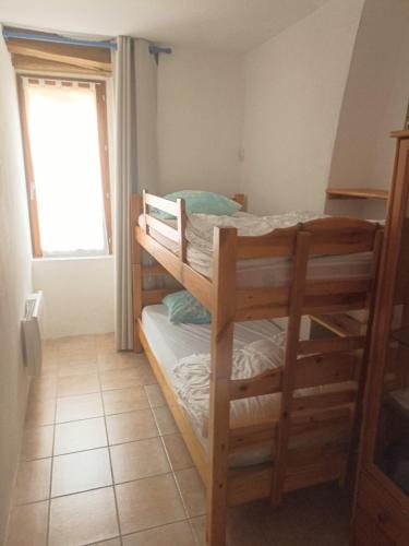 deux lits superposés dans une chambre avec fenêtre dans l'établissement Gîte le Petit Riou, à Sainte-Marguerite-Lafigère