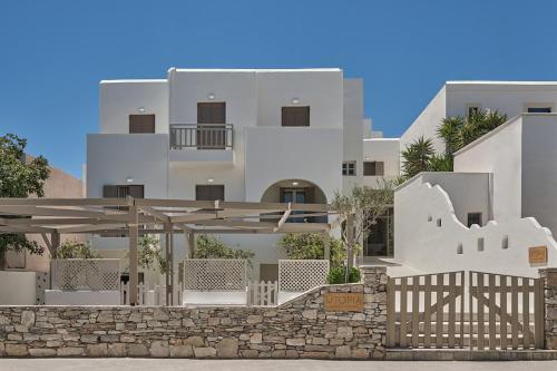 a white building with a fence in front of it at Utopia Hotel in Koufonisia