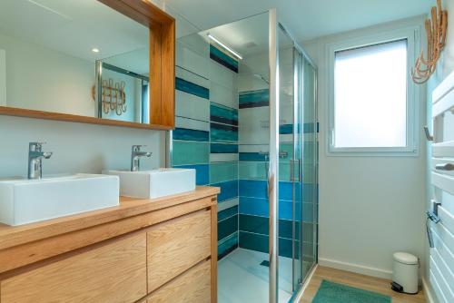 a bathroom with two sinks and a shower at Ty Glaz - Maison à 900m de la plage in Fouesnant