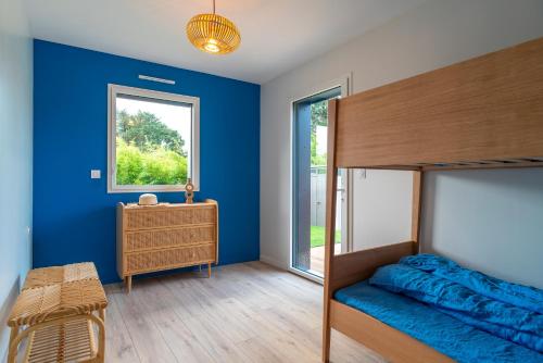 um quarto com paredes azuis, uma cama e uma janela em Ty Glaz - Maison à 900m de la plage em Fouesnant