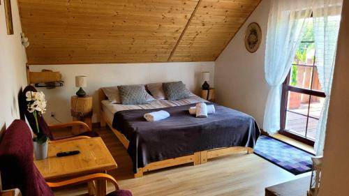 1 dormitorio con cama, mesa y ventana en Agroturystyka Kasprzykówka, 