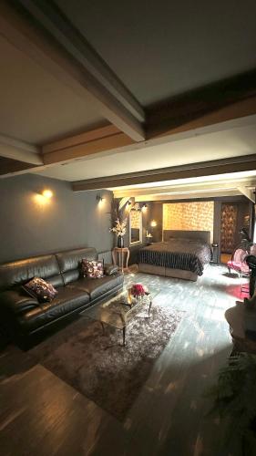 un salon avec un canapé et une table dans l'établissement LA BLACK ROOM / Les suites romantiques à Honfleur centre historique, à Honfleur