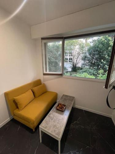 une chambre avec un canapé, une table et une fenêtre dans l'établissement Studette cosy entièrement rénovée, à Paris