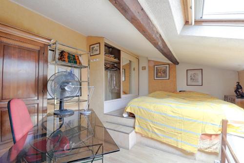 Schlafzimmer mit einem Bett und einem Glastisch mit einem Ventilator in der Unterkunft Bamboos Garden - Appartement climatisé in Malakoff