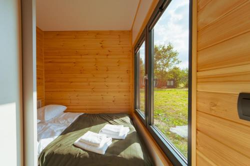 - une petite chambre avec fenêtre dans une petite maison dans l'établissement Arche Siedlisko Piłka Boisko, 