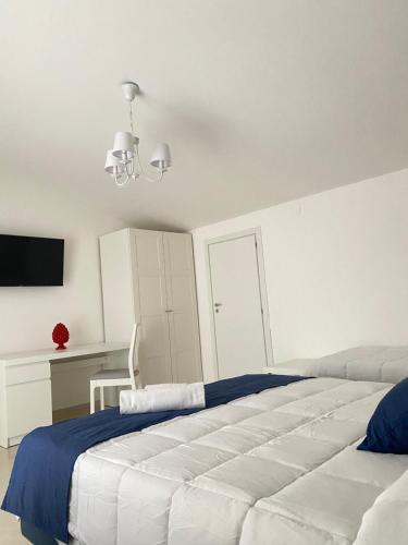 a white bedroom with a large bed and a desk at Vista al Tramonto B&B in Falerna