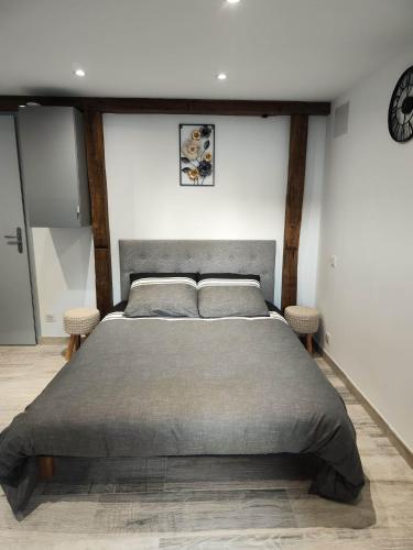 een slaapkamer met een groot bed en 2 stoelen bij Le domaine des Reverets in Trézelles