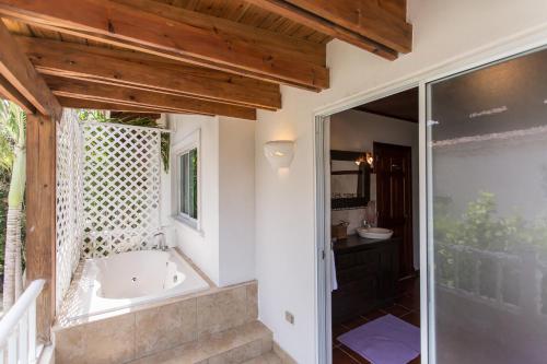 蓬塔卡納的住宿－A Golf Lover's Dream Villa with 4 Bedrooms, Pool, Jacuzzi, and Maid，一间位于窗户旁的带浴缸的浴室