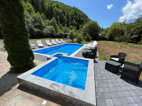 a swimming pool with lounge chairs and a swimming pool at Villa Green Heaven in Sarajevo